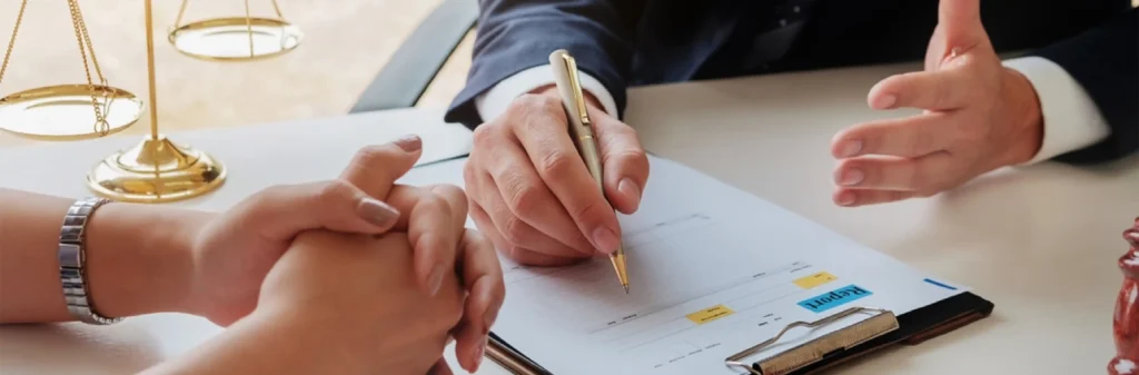 Image of a scale of justice and hands signing documents, representing the mediation process for family law disputes at Summit Conflict Resolution.