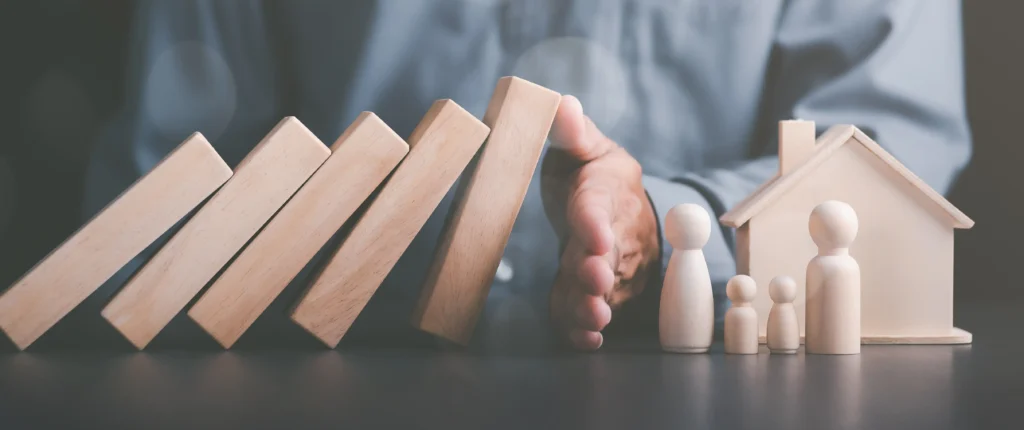 Image of wooden blocks and a family figurine with a house, symbolizing family dispute resolution through mediation services at Summit Conflict Resolution.