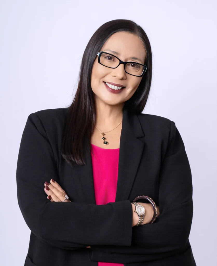 Janelle Rollo from Summit Conflict Resolution standing confidently with arms crossed in a black suit for family dispute resolution.